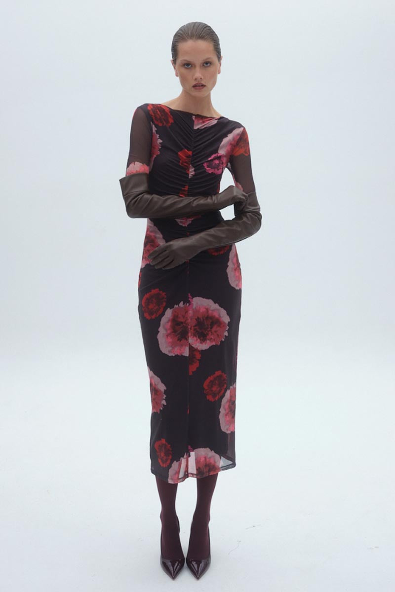 Woman wearing a black dress with red floral patterns on a white background