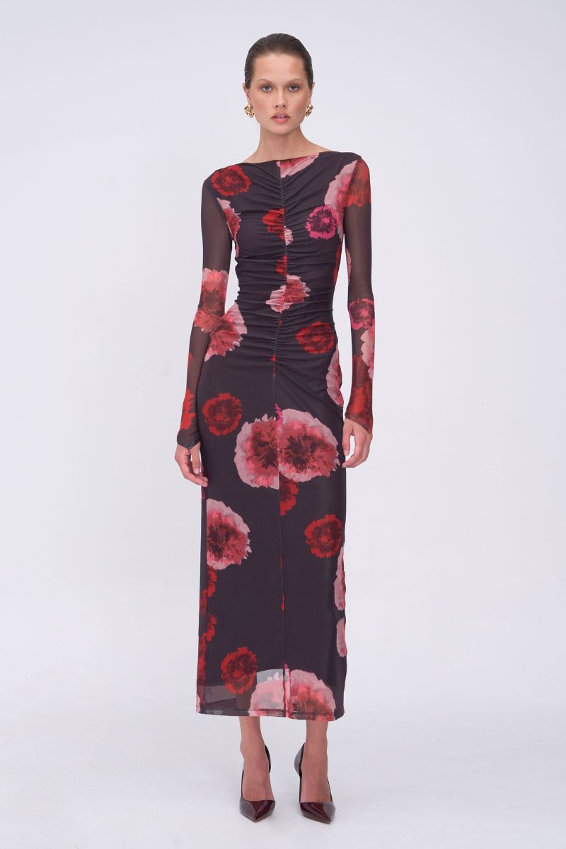 Model wearing a floral dress with red and pink flowers on a white background