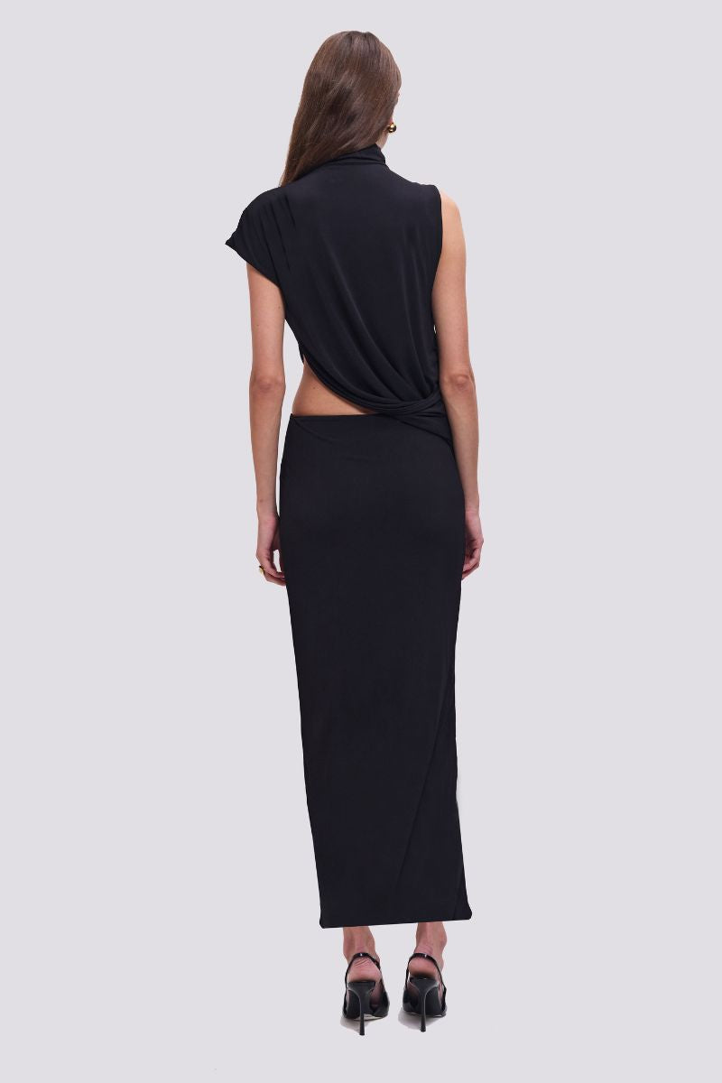 Woman wearing a black outfit with a draped top and long skirt on a white background