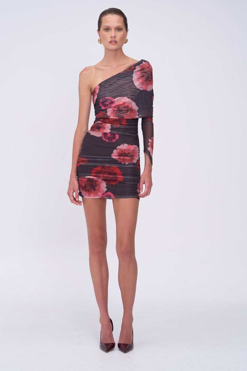 Model wearing a one-shoulder dress with floral pattern on a white background