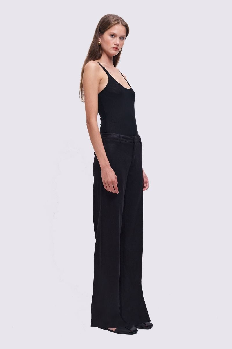 Woman wearing a black sleeveless top and black pants