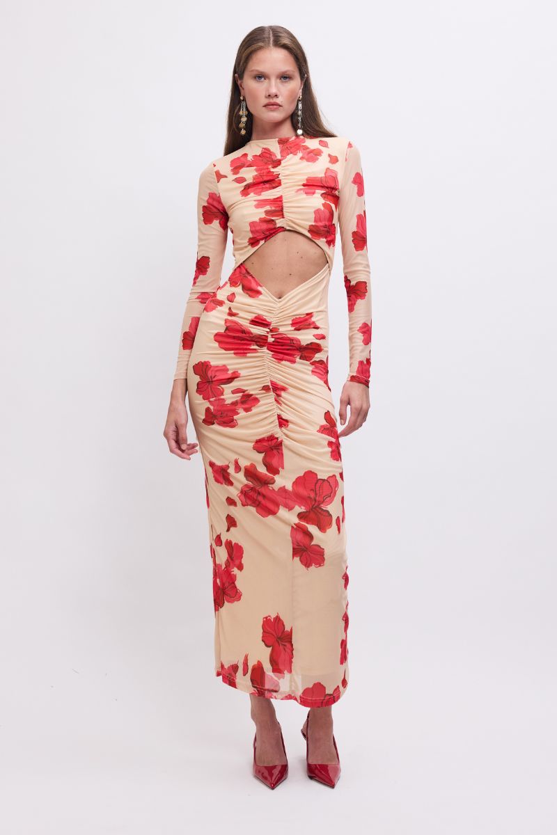 Woman wearing a red and beige floral dress with cut-out design on a white background